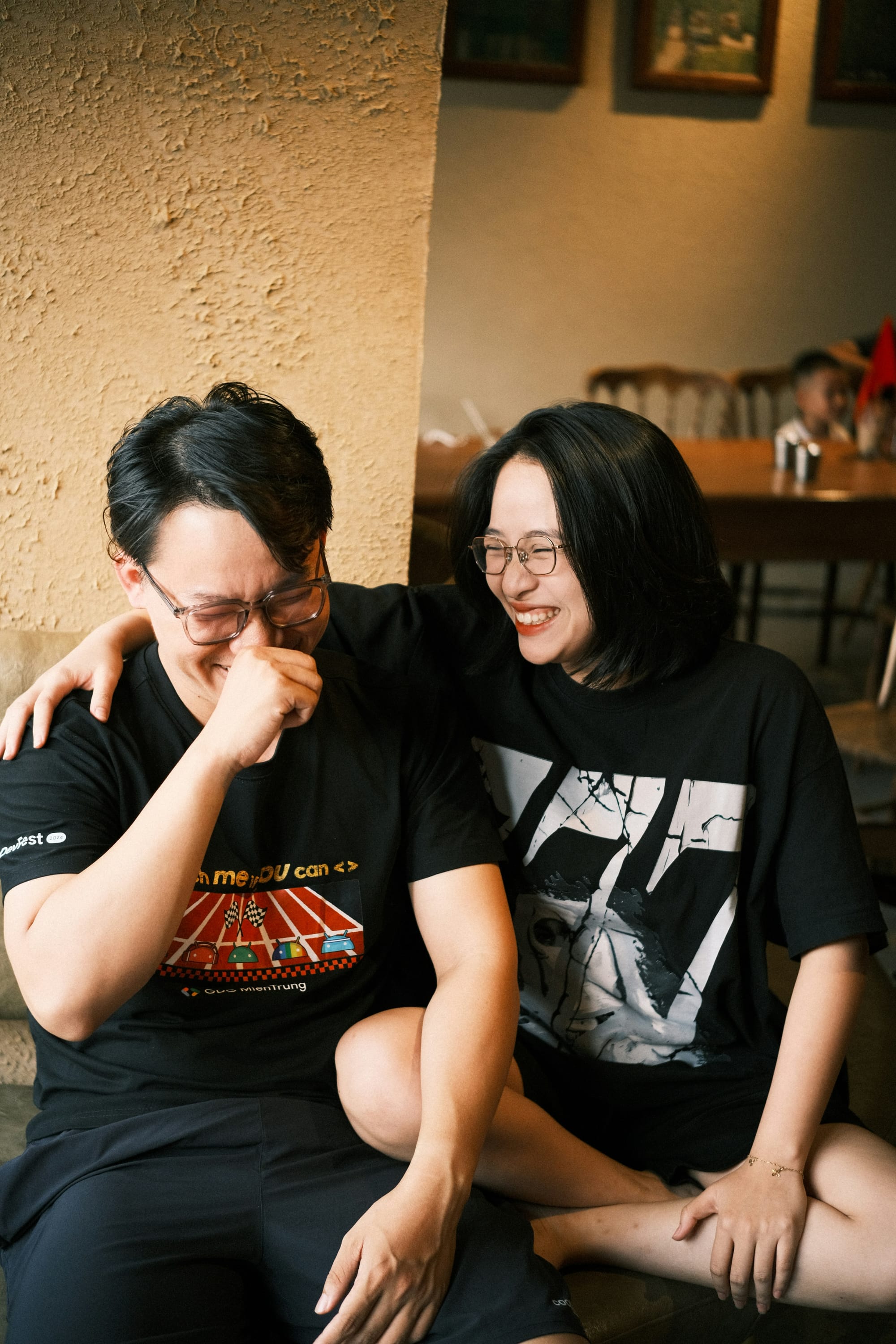 Two people laughing together on a couch