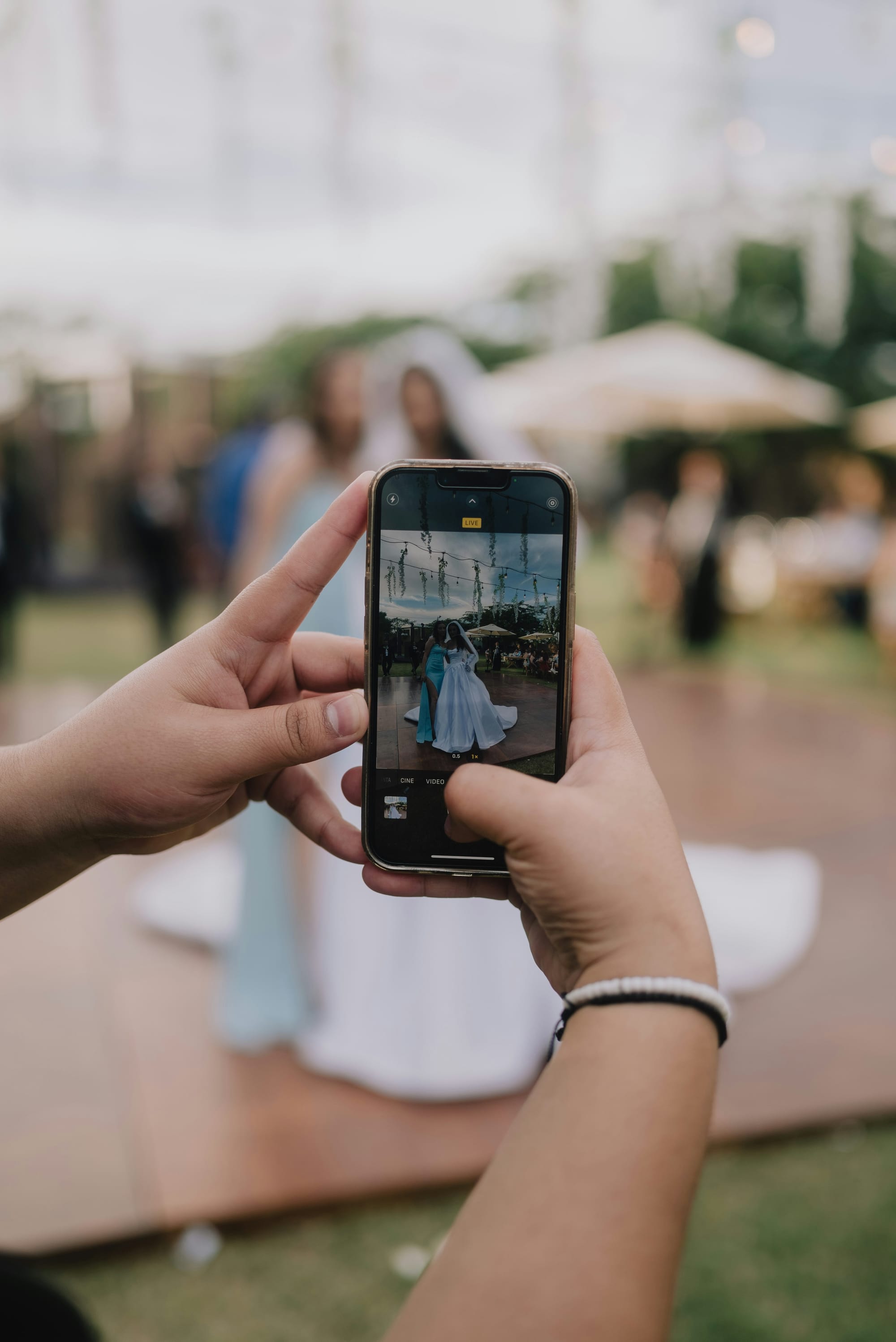 A phone capturing a couple at a wedding celebration